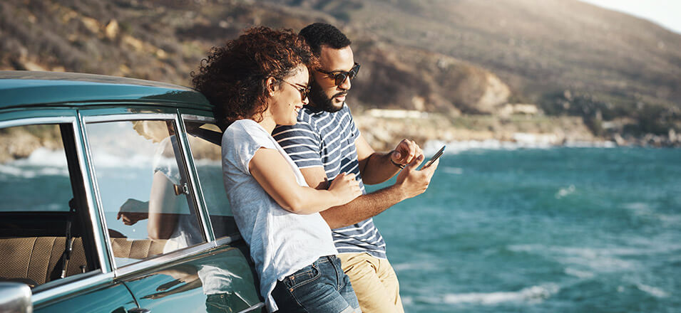 Couple using phone on a road trip