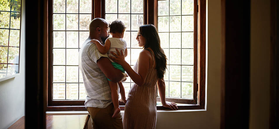 family looking out window of their home