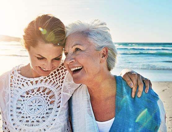 older woman on beach with daughter 