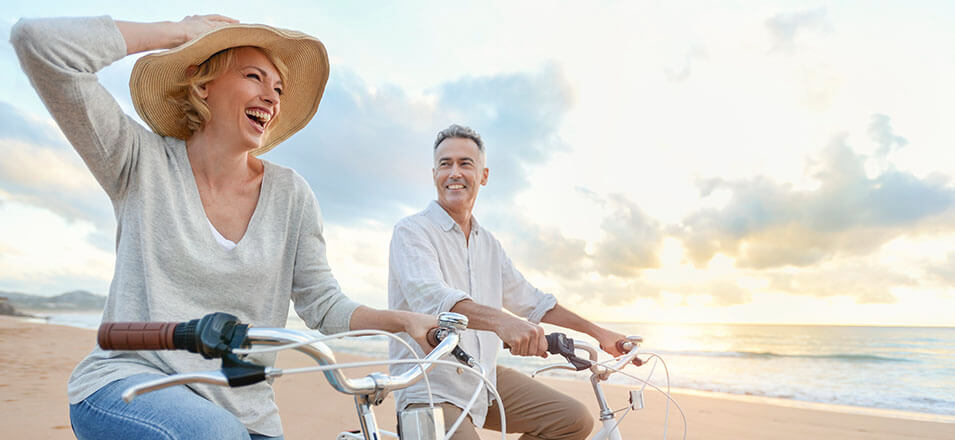 A couple riding bikes on the beach