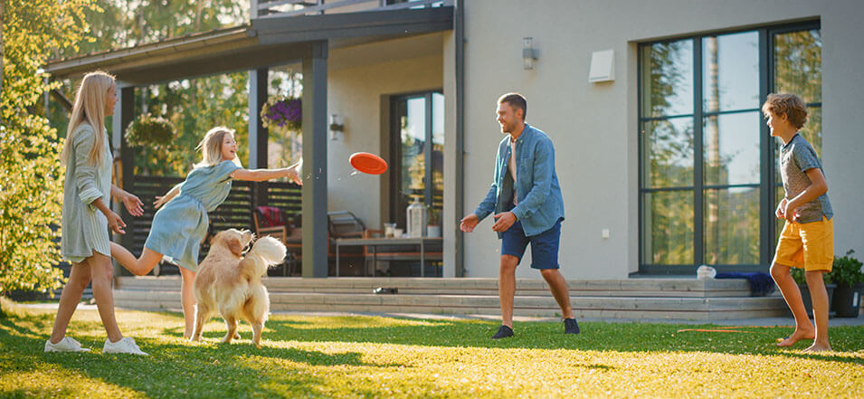 family playing in yard in front of home