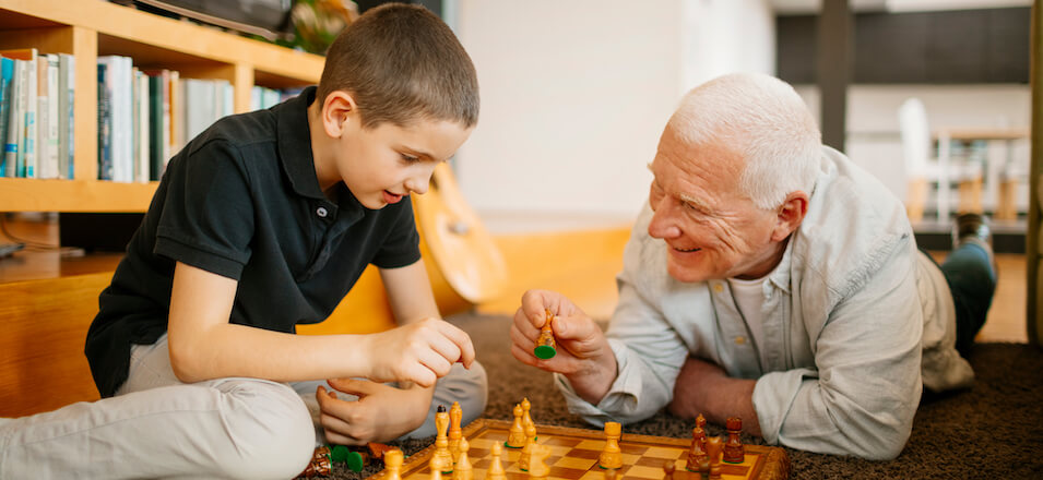 Grandpa playing chess with child
